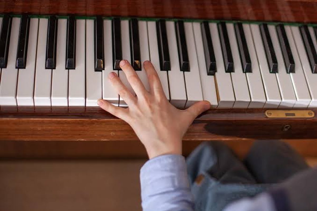 Child's hand practicing piano keys